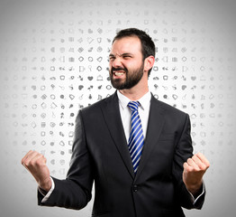 Young business man winner over background with icons