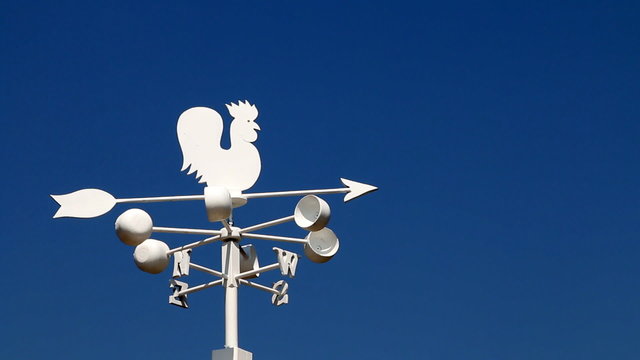 Wind cock direction rotate on blue sky background.