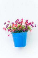 Plastic flower in vase on wall background