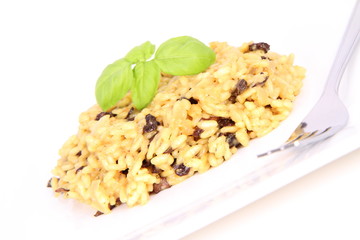 Risotto with mushrooms on a plate decorated with basil