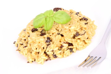 Risotto with mushrooms on a plate decorated with basil