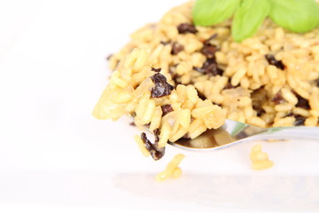 Risotto with mushrooms eaten with a fork on a white background