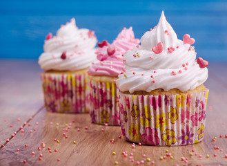 Cupcakes with white and pink cream with blue background