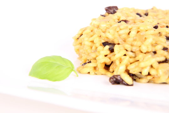 Risotto with mushrooms on a plate decorated with basil