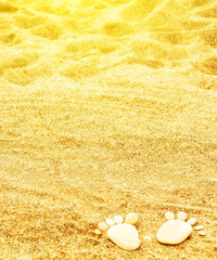 footprints of stones on yellow sand on the beach in summer © JenkoAtaman