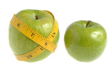 One green apple wrapped with measuring tape and another green ap