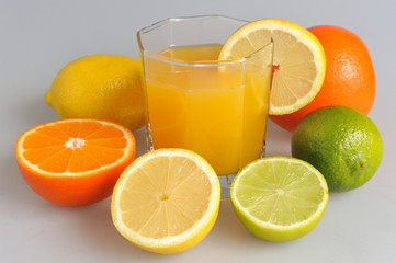 Some kind of citrus with the glass filled with citrus juice on t