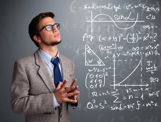Handsome school boy thinking about complex mathematical signs