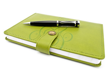 Pen and green notebook isolated on white