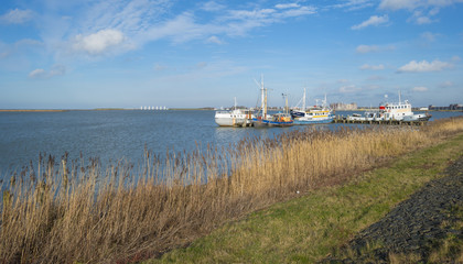 Boats in a harbor along a dike in winter