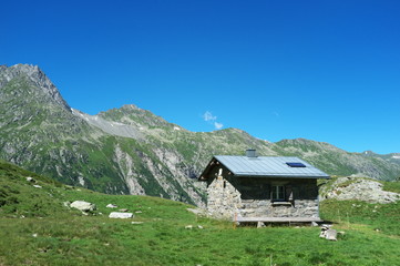 Fototapeta na wymiar Alpine hut on a high mountain scene
