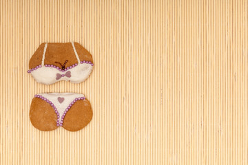 White violet bikini shape gingerbread cake cookie on bamboo mat