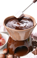 Chocolate fondue with marshmallow candies and fruits, isolated