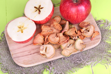 Dried apples, on cutting board,  on color wooden background
