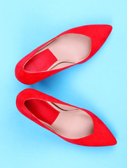 Beautiful red female shoes, on blue background