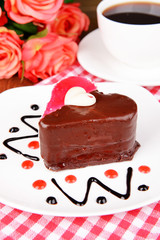Sweet cake with chocolate on plate on table close-up