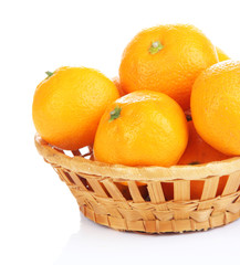 Ripe sweet tangerines in wicker basket, isolated on white