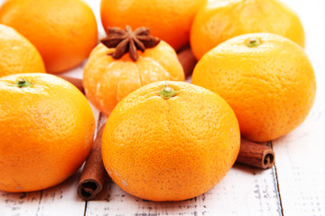 Ripe sweet tangerines and spices, on wooden background