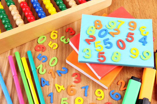 Colorful numbers, abacus, books and markers on wooden