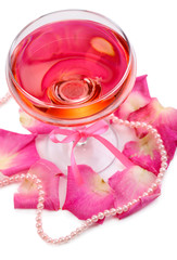 Composition with pink sparkle wine in glass and  rose petals