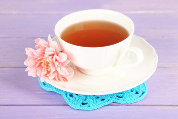 Fototapeta na wymiar Pink chrysanthemum and cup of tea on wooden table