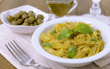 Delicious pasta with pesto on plate on table close-up