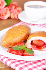 Fresh baked pasties with strawberries on plate on table