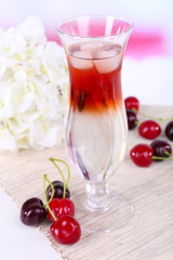 Glass of cocktail on table on light background