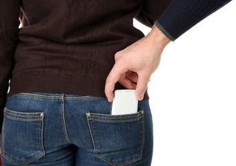 Pickpocket are stealing mobile phone from back pocket, close