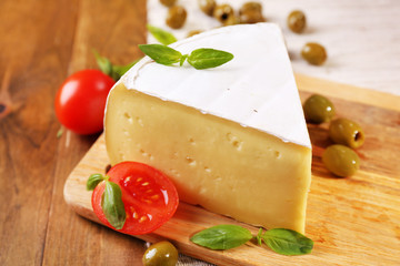 Tasty Camembert cheese with tomatoes, olives and basil,