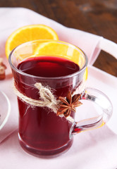 Mulled wine with oranges on table close up