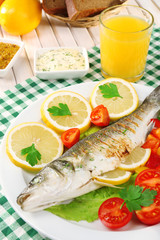 Delicious grilled fish on plate on table close-up