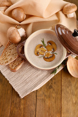 Fototapeta na wymiar Mushroom soup in pot, on wooden background