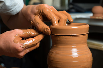 hands of a potter, creating an earthen jar