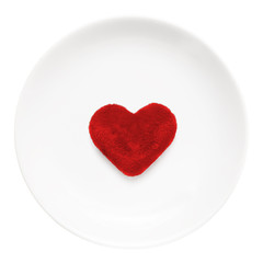 Red heart on a plate close-up isolated on a white background