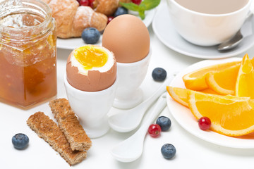 breakfast with eggs, toasts, croissant, fresh berries and orange