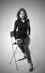 Obraz na płótnie Canvas brunette in jeans sitting on chair