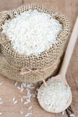 rice in a burlap bag on wooden surface
