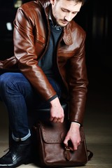 Fototapeta na wymiar Fashionable young man with leather clothes on