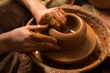 hands of a potter, creating an earthen jar