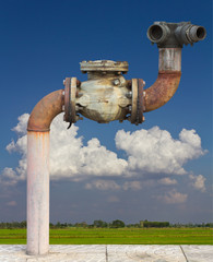 Old pipe on the floor, with the fields and the sky