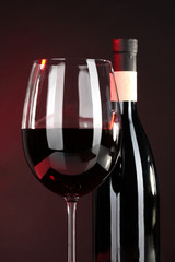 Wine in glass and wine bottle close-up on dark background