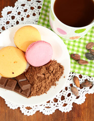 Cocoa in cup with sweets and cocoa powder