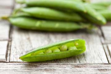 Peas and pods on an old wooden teak table