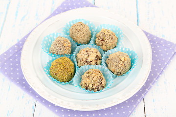 Set of chocolate candies, on plate, on wooden background
