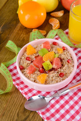 Delicious oatmeal with fruit in bowl on table close-up