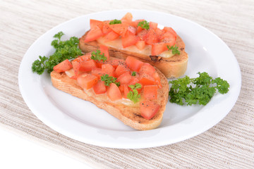 Delicious bruschetta with tomatoes on plate on table close-up