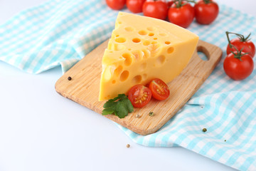 Piece of cheese and tomatoes, on wooden board, isolated on