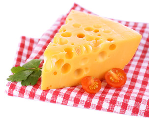 Piece of cheese and tomatoes,on color napkin, isolated on white