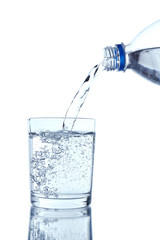Pour water from bottle into  glass, on light blue background